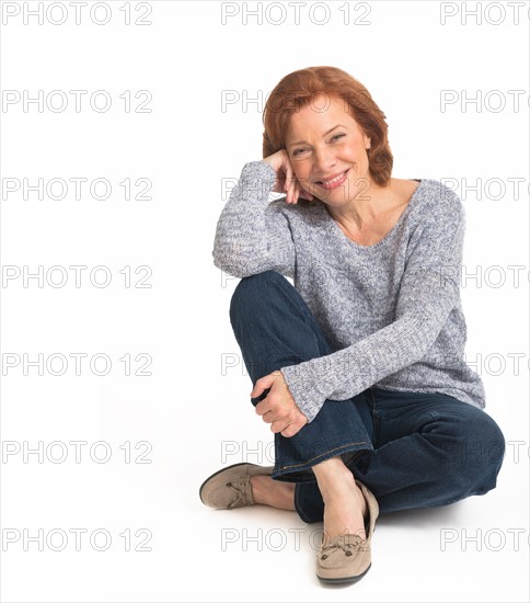 Studio shot of senior woman smiling.