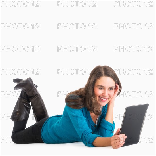 Studio shot of young woman using laptop.