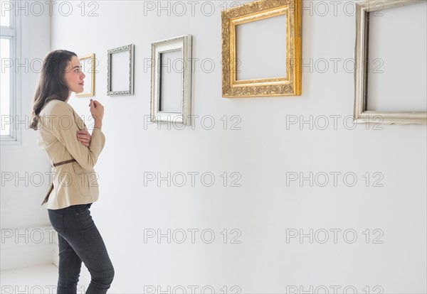 Woman looking at blank pictures in art gallery.