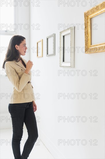 Woman looking at blank pictures in art gallery.