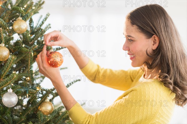 Woman decorating christmas tree.