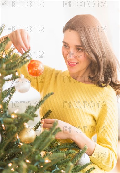 Woman decorating christmas tree.