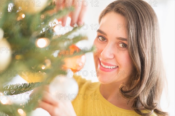 Woman decorating christmas tree.