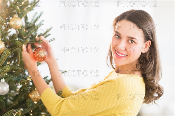 Woman decorating christmas tree.