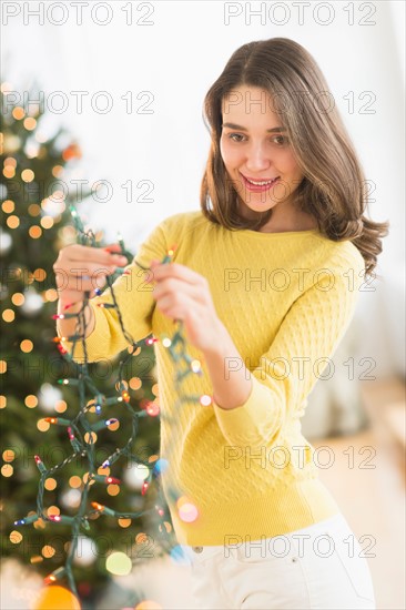 Woman decorating christmas tree.