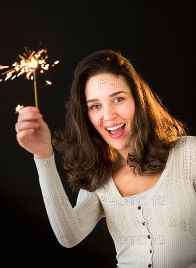 Woman holding sparkler.