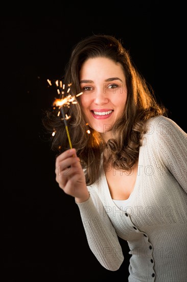 Woman holding sparkler.