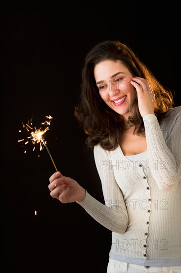 Woman holding sparkler.