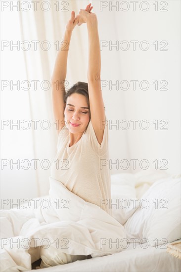 Woman stretching on bed.