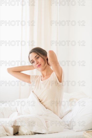 Woman stretching on bed.