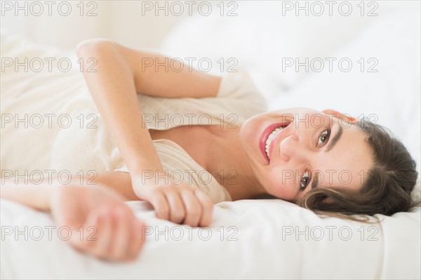 Portrait of young woman lying in bed.