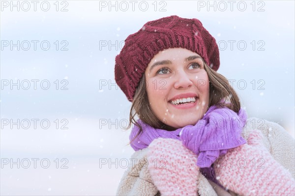 Portrait of young woman wearing knit hat, gloves and scarf.