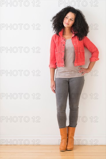 Portrait of smiling mid adult woman standing against wall.