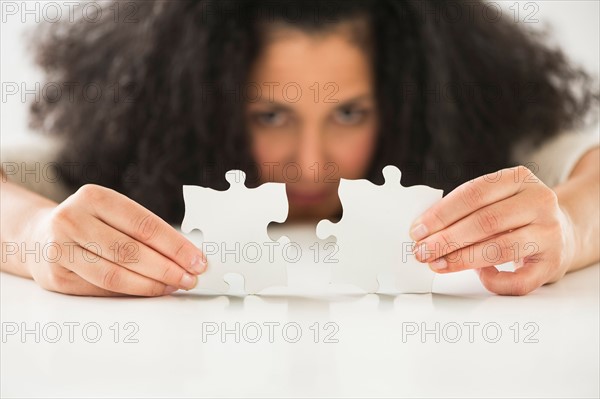 Close up of woman's hands matching jigsaw puzzle.