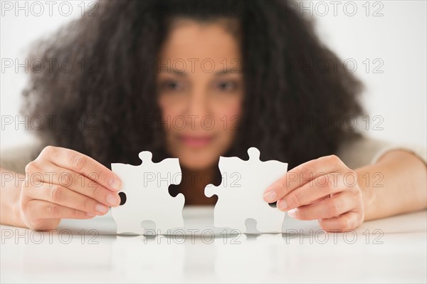 Close up of woman's hands matching jigsaw puzzle.