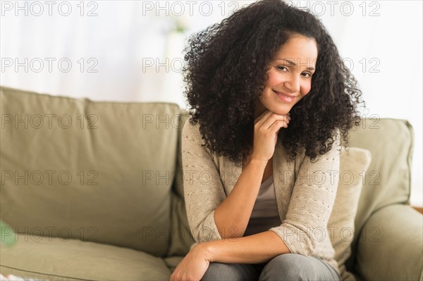 Portrait of mid adult woman sitting on sofa.