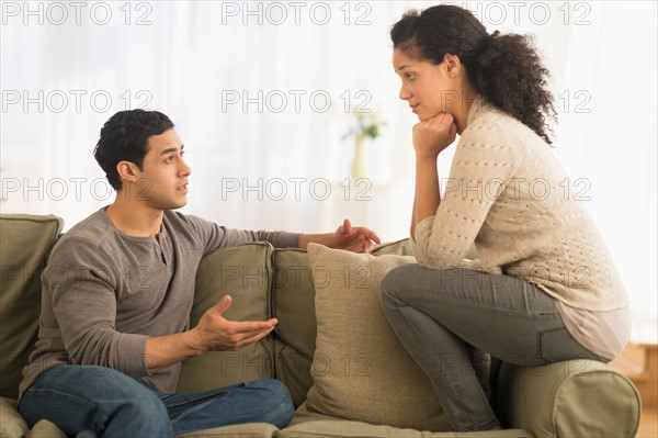 Couple talking on sofa.