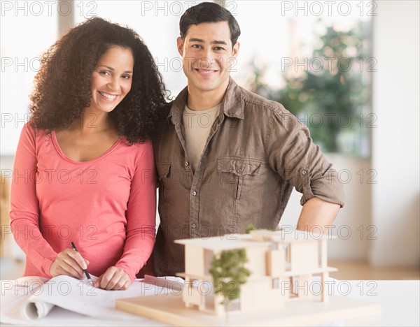 Smiling couple with model home.