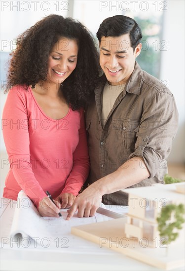 Smiling couple with model home.