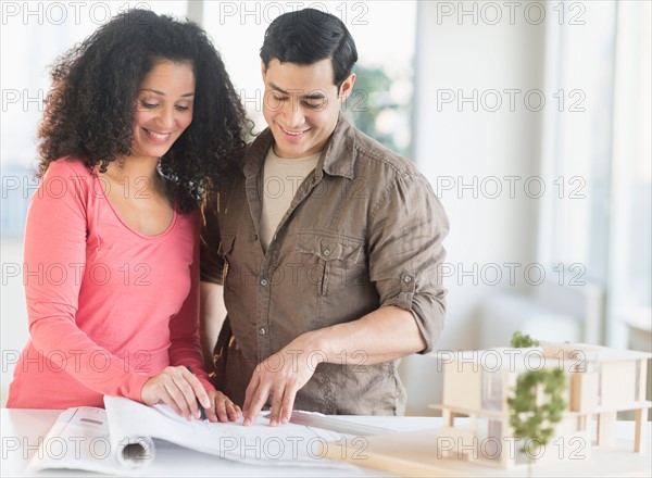 Smiling couple with model home.