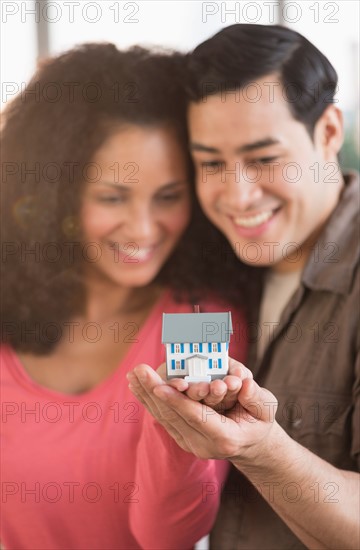 Smiling couple with model home.