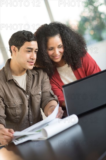 Smiling couple planning home ownership with model home.