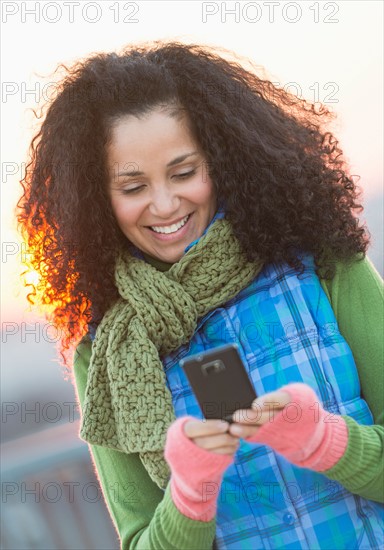 Portrait of mid adult woman using mobile phone at sunset.