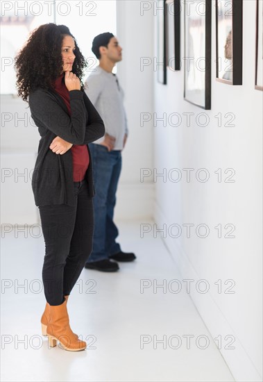 Visitors looking at artworks in gallery.