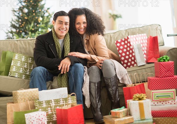 Couple with Christmas presents in living room.