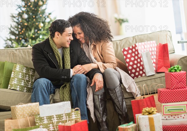 Couple with Christmas presents in living room.