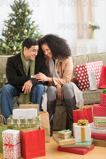 Couple with Christmas presents in living room.