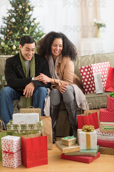 Couple with Christmas presents in living room.