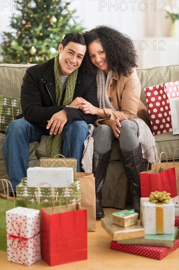 Couple with Christmas presents in living room.