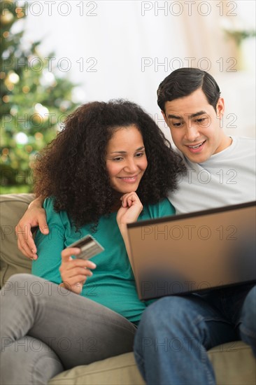 Couple using laptop for online shopping.