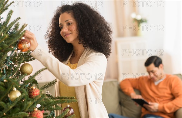 Woman decorating Christmas tree.