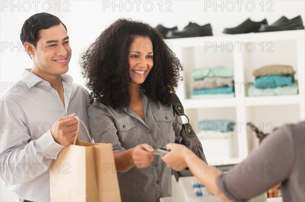 Customers and sales clerk in store.