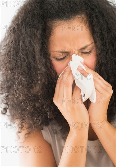 Woman blowing nose.