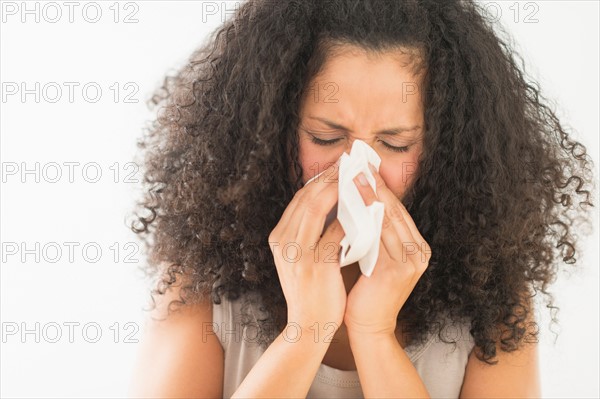 Woman blowing nose.