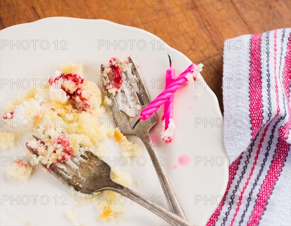 Candles on plate with scraps of cake.