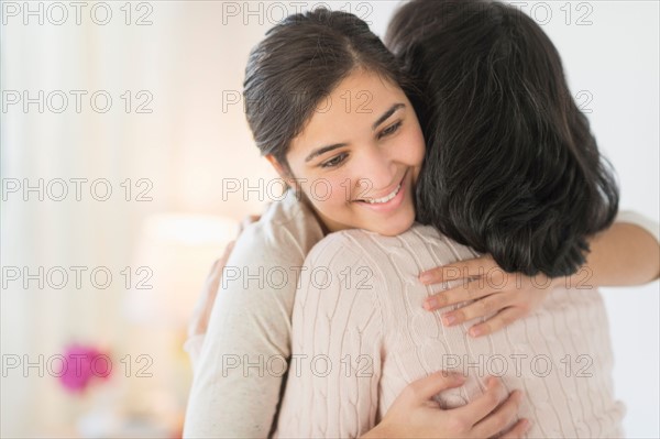 Grandmother and granddaughter (16-17) embracing.