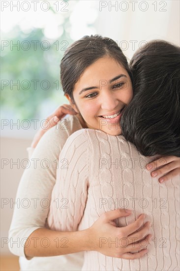 Grandmother and granddaughter (16-17) embracing.