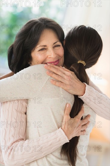 Grandmother and granddaughter (16-17) embracing.