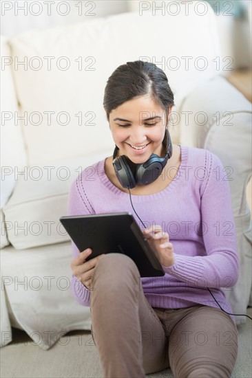 Portrait of teenage girl (16-17) with digital tablet and headphones.