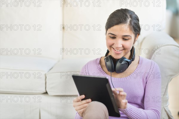 Portrait of teenage girl (16-17) with digital tablet and headphones.