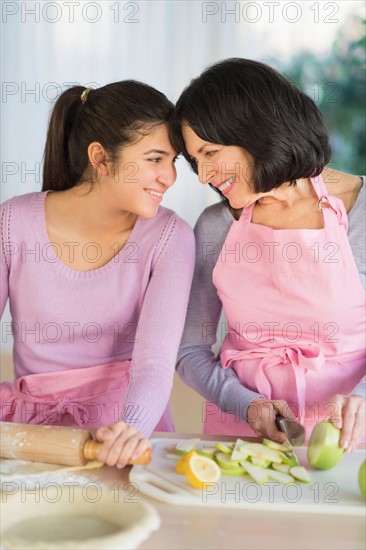 Grandmother and granddaughter (16-17) baking together.