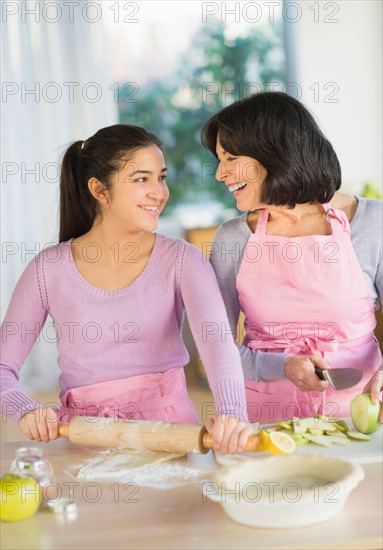 Grandmother and granddaughter (16-17) baking together.