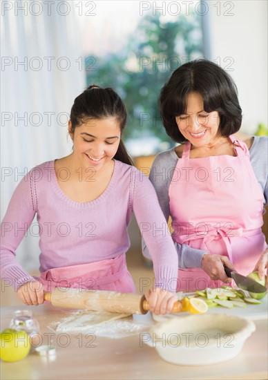 Grandmother and granddaughter (16-17) baking together.