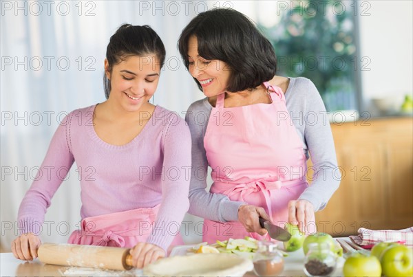 Grandmother and granddaughter (16-17) baking together.