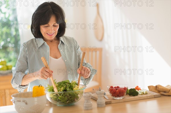 Senior woman preparing salad.