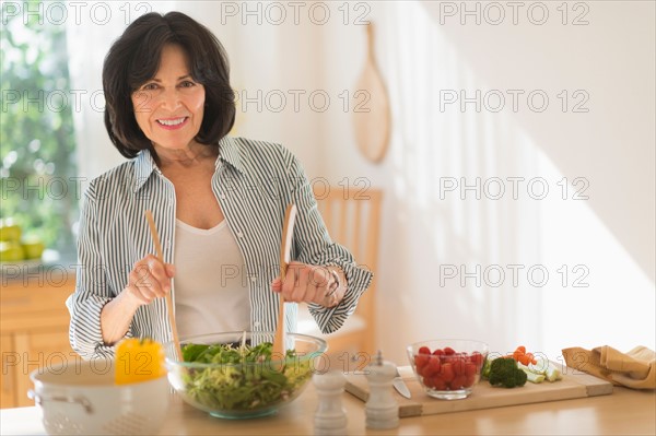 Senior woman preparing salad.